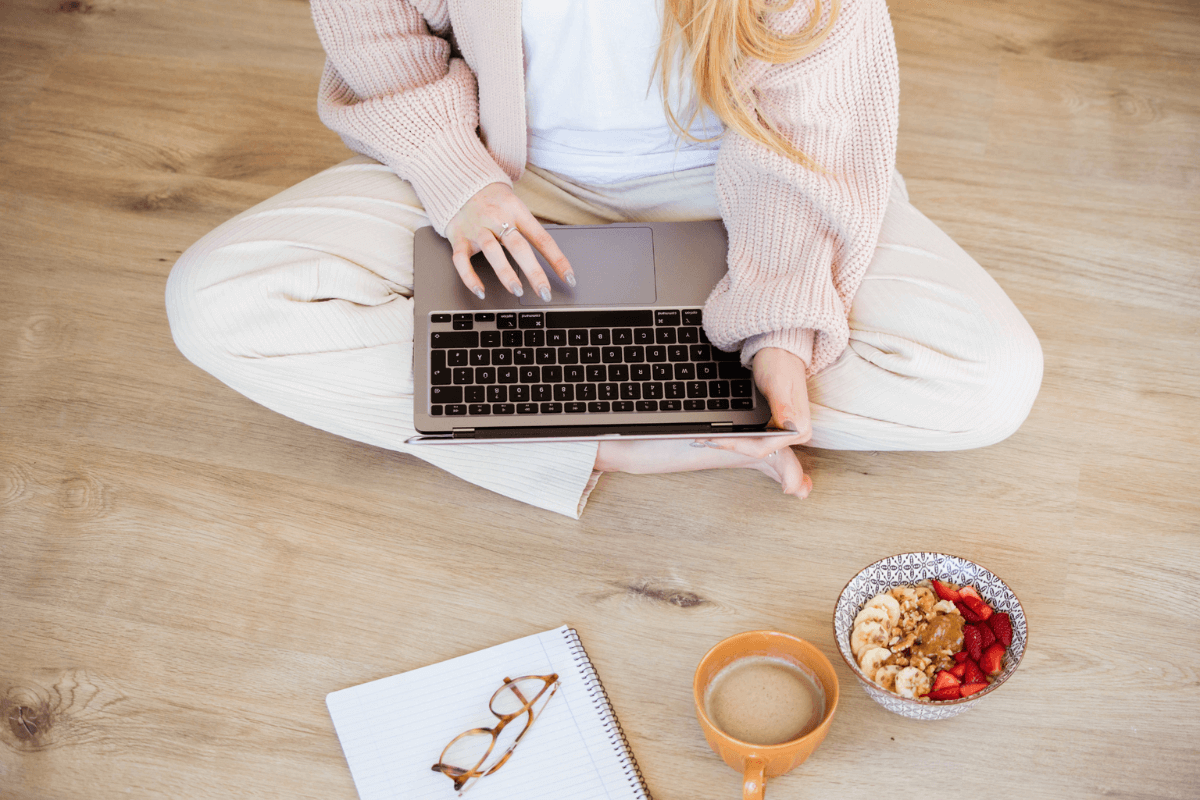 women sitting on floor working on laptop