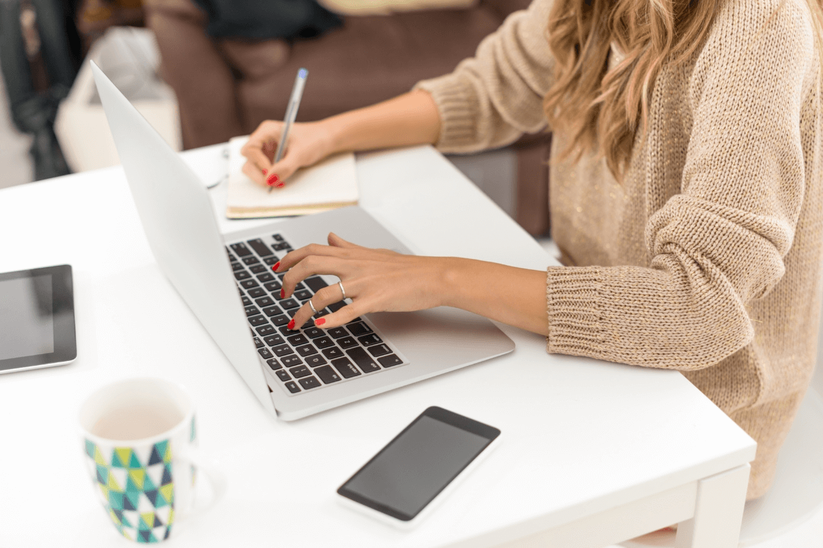 woman sitting at a desk with laptop and notepad